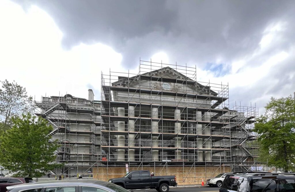 The main façade of Memorial Continental Hall on 17th Street. Marble was cleaned and repaired. Black soot can be easily observed on the central pediment. The complex scaffolding took many weeks to be constructed by a specialized subcontracted crew.