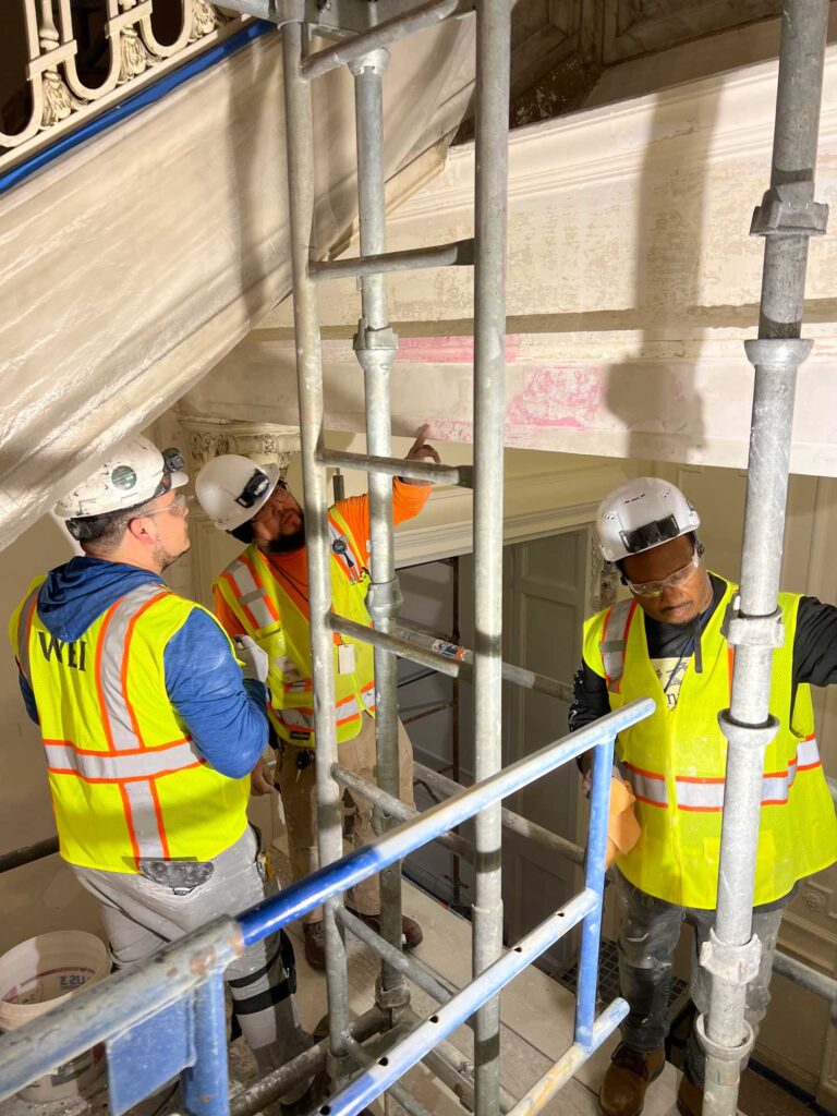 Interior work foreman Oscar Bonilla (center) conferring with his team about the repairs.